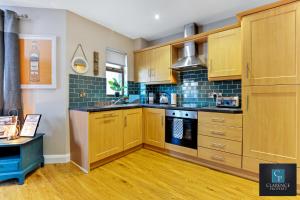 a kitchen with wooden cabinets and a stove at Causeway Coast Haven in Ballycastle