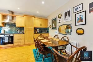 a kitchen and dining room with a wooden table and chairs at Causeway Coast Haven in Ballycastle