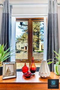 a window with three red vases sitting on a table at Causeway Coast Haven in Ballycastle