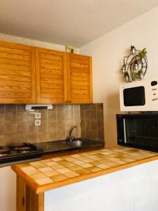 uma cozinha com armários de madeira, um lavatório e um micro-ondas em Hameau de Souaribes 2 em Luz-Saint-Sauveur