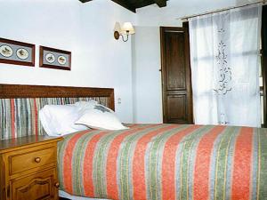 1 dormitorio con 1 cama, vestidor y ventana en Casa Rural La Cueva, en Casas del Castañar