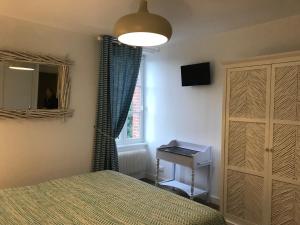 a bedroom with a bed and a dresser and a window at Chambres d'Hôtes Le Clos Tassin in Colleville-sur-Mer