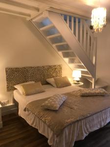 - une chambre avec un grand lit et un escalier dans l'établissement Chambres d'Hôtes Le Clos Tassin, à Colleville-sur-Mer