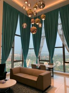 a living room with green curtains and a couch at EvoskyhomeBangi Duplex Suite Bangi Sentral in Kampong Sungai Ramal Dalam