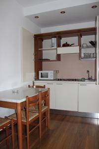 a kitchen with white cabinets and a table and chairs at Banu Manta Apartments in Bucharest