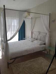 - une chambre avec un lit à baldaquin et une fenêtre dans l'établissement Apartament Stegeo Tudor's Residence, à Mamaia