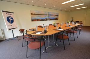 uma sala de conferências com uma mesa longa e cadeiras em Fletcher Hotel-Restaurant de Borken em Dwingeloo