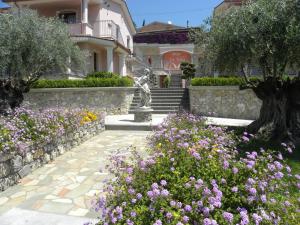 a garden with flowers and a statue in front of a house at Hotel Ristorante Borgo La Tana in Maratea