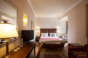 a hotel room with a bed and a television at Electra Hotel Athens in Athens
