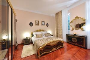 a bedroom with a bed and a mirror on the wall at Old Town Jacuzzi Suite in Zadar