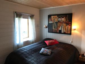 a bedroom with a bed with a red pillow on it at Cape East Homestay in Ytre Kiberg