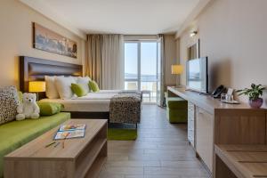 a hotel room with a bed and a television at Hotel Pinija in Petrcane