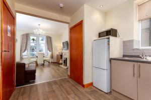 a kitchen with a refrigerator and a dining room at Beachcliffe Lodge Apartments in Blackpool