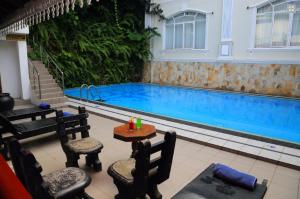 a swimming pool with two chairs and a table and a table sidx sidx at Centauria Hill Resort in Ratnapura