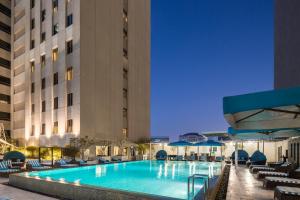 a large swimming pool in a large city at Novotel Deira City Centre in Dubai