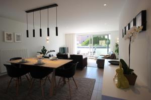 a dining room and living room with a table and chairs at Vakantiewoning De Konijnenweg in De Panne