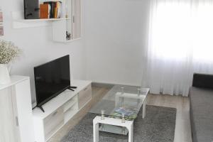 a living room with a flat screen tv and a chair at La CaSa De Su in Gijón