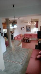 Aiándion的住宿－Prosili，客厅配有粉红色的沙发和桌子