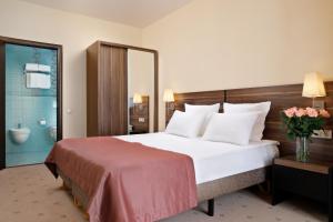 エッセントゥキにあるMedical Spa Resort Russの大きなベッドとバスルームが備わるホテルルームです。