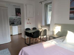 a bedroom with a bed and a table and chairs at Szélrózsa apartmanház in Velence