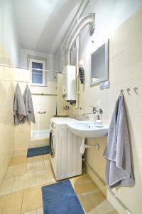een badkamer met een wastafel en een wasmachine bij Luxury Retro Apartment, City Center, WiFi in Krakau