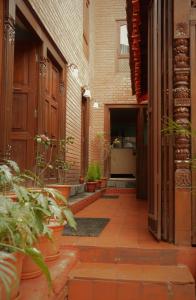 a courtyard of a building with potted plants at Inn Sangrahalaya in Bhaktapur