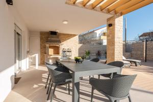 a dining area with a table and chairs on a patio at Villa Divino Afflante in Pirovac