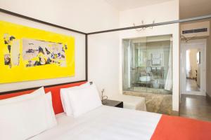 a bedroom with a white bed and a yellow painting at Residenze Argileto in Rome