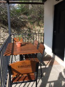 una mesa de madera y una silla en un porche en Four Seasons Apartment en Sighnaghi