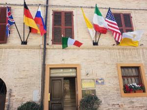 um grupo de bandeiras na lateral de um edifício em Domus Pacis Santa Chiara casa per ferie em Loreto