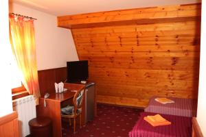a room with a desk with a computer and a bed at семеен хотел Визаж in Yambol
