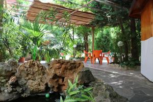 a patio with a table and chairs and plants at семеен хотел Визаж in Yambol