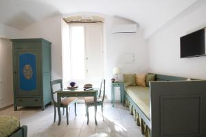 un soggiorno con letto e tavolo e una sala da pranzo di Duomo Gallipoli B&B and Apartments a Gallipoli