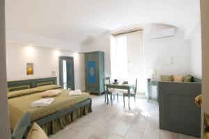 1 dormitorio con cama, escritorio y mesa en Duomo Gallipoli B&B and Apartments, en Gallipoli
