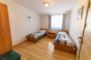 a room with two beds and a window at Apartamenty Rodzinne Zdrojowe in Kudowa-Zdrój