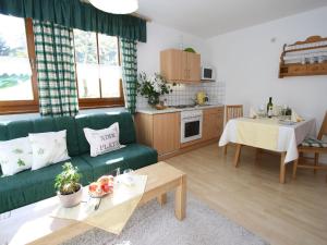 a living room with a green couch and a table at Apartment close to the ski area in Hüttschlag