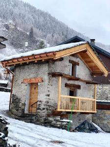 Cette petite maison dispose d'un balcon en bois dans la neige. dans l'établissement le mazot d'urbain, à Tignes
