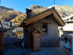 a small stone building with a roof with a window at le mazot d'urbain in Tignes