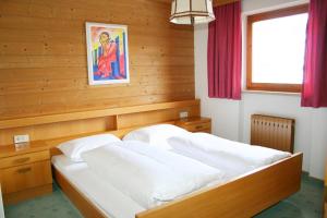 a bedroom with two beds in a wooden room at Sunshine Appartements in Fiss