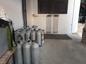 a group of silver gas cylinders lined up in a room at Raya Del Sol Dive Resort in Mabini