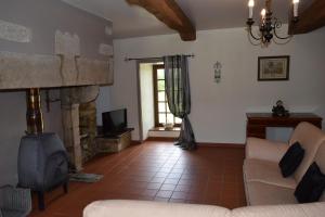 a living room with a couch and a fireplace at Chambre d'hôte Manoir de La Baudonnière in Monsireigne