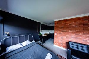 a bedroom with a bed and a brick wall at Apartamenty na Chopina in Kielce