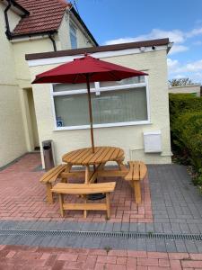 a picnic table with an umbrella on a brick patio at Oxford Bed and Breakfast in Oxford