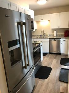 a kitchen with a stainless steel refrigerator and white cabinets at The Countrypolitan in Lewisburg