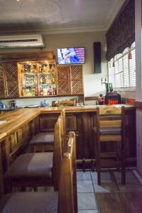 a bar with chairs and a television on the wall at Border Hotel in Jan Kempdorp