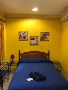 1 dormitorio con 1 cama con edredón azul en Pensión Macarena, en Sevilla