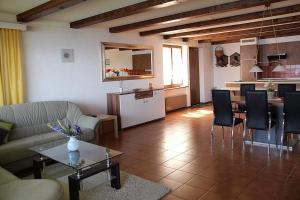 ein Wohnzimmer mit einem Sofa und einem Tisch mit Stühlen in der Unterkunft Brissago: Casa Collinetta H in Brissago