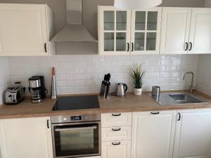 a kitchen with white cabinets and a sink at Ferien Hus am Klüt in Hameln