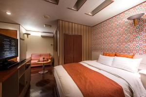 En eller flere senge i et værelse på Hotel Noanoa