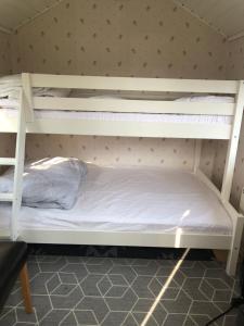 two bunk beds in a room with a white bed at Two small Guest houses by lake rent out as One in Hjo